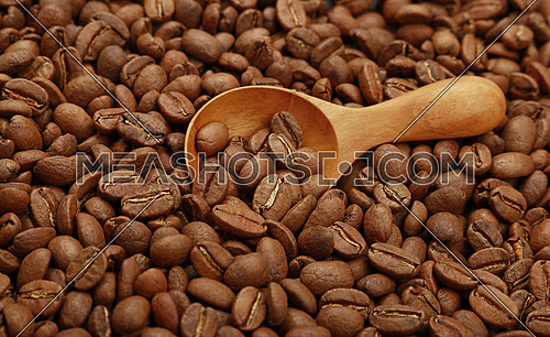Close up wooden scoop with roasted coffee beans, elevated top view, high angle view