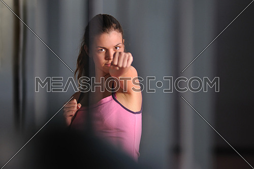young fighter girl practicing fitness exercise in fitness club