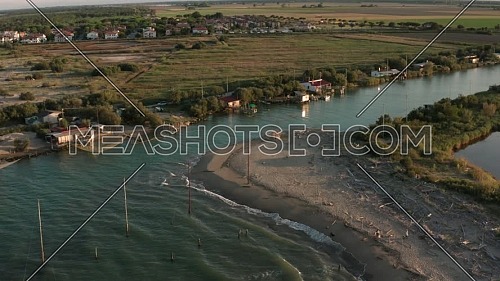 Aerial shot of the valleys near Ravenna (Fiumi Uniti) where the river flows into the sea with the typical fishermen's huts.