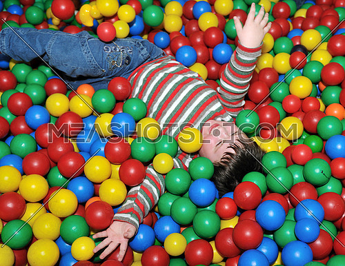 happy child playing in colorful balls pool