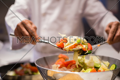 hands chef while preparing a meal of vegetables with satisfaction