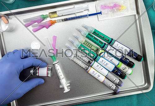 Syringes of insulin medication next to medicine vials prepared in hospital, conceptual image, horizontal composition