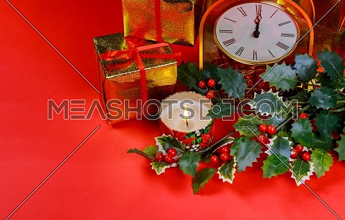 Christmas and New year clock decorations on burning candle, decorations, on red background