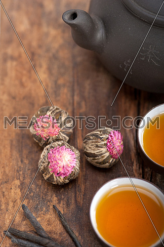Chinese style herbal floral tea over wood table with raw ingredients