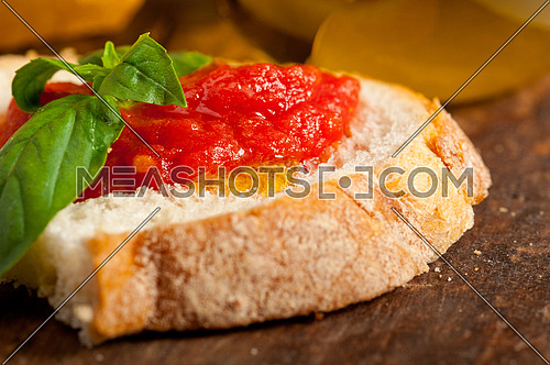 Italian fresh tomato and basil bruschetta with pecorino cheese over old wood