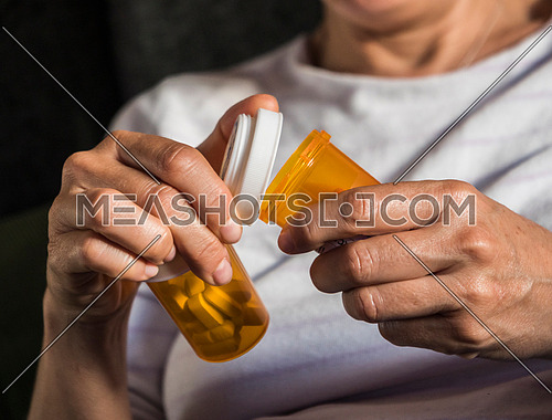 Woman opening pill jar in her hands, conceptual image