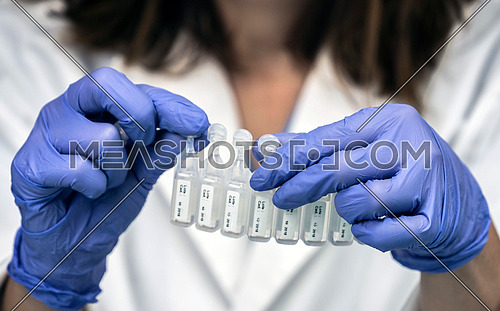 Nurse prepares medication in ampoules for oxygen mask in a hospital, conceptual image