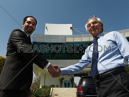 business people handshake and make deal  in front of modern corporate  building