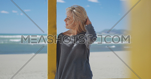 Young woman on the beach. The girl enjoying the warm autumn day. Portrait of beautiful girl near the water