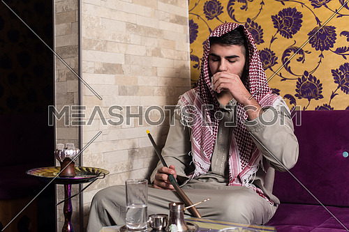 Muslim Man Smoking Turkish Hookah In The Cafe With Colorful Walls On Background