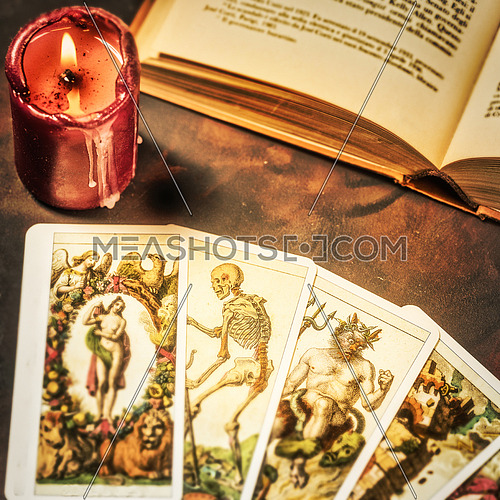 View from above of tarot cards with candlelight and book on the darkness background,Halloween and future reading concept.