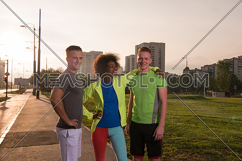 Portrait of multi-ethnic group of young people on the jogging beautiful summer evening as the sun sets over the city