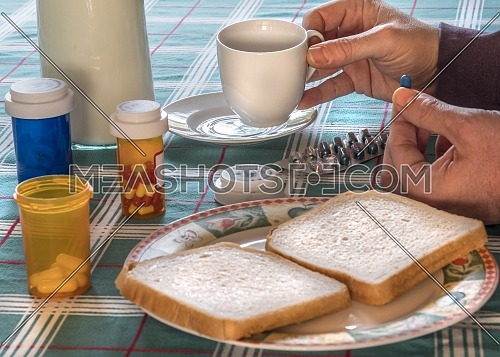 Person takes medication during breakfast, conceptual image