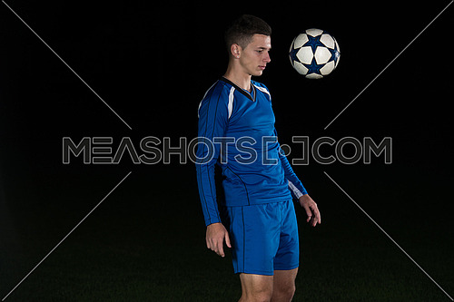 Soccer Player Doing Kick With Ball On Football Stadium Field Isolated On Black Background