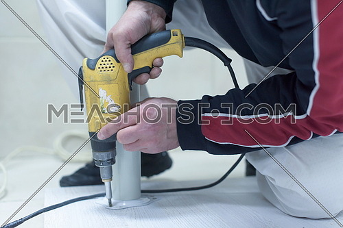 repairman working with drilling machine and assambling  furniture
