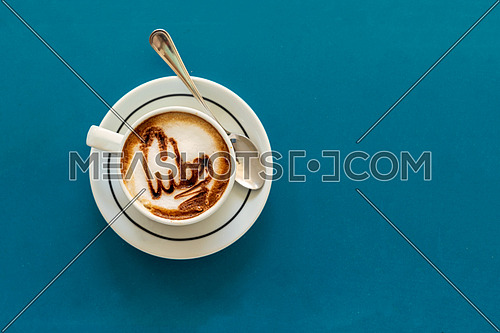Capuccino on a cup with foam and above the foam the inscription Cuba on a turquoise background