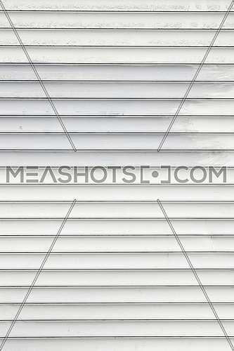 White dirty horizontal metal window roller shutter blinds background with gray paint strokes