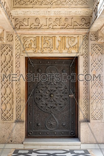 Closed wooden aged door with ornate bronzed floral patterns at the public mosque attached to The Manial Palace of Prince Mohammed Ali Tewfik, Cairo, Egypt