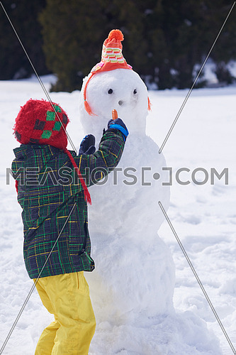 little boy making snowman