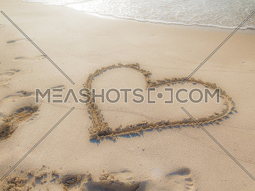 Love sign written on sand on a beach