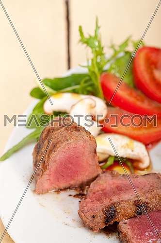 beef filet mignon grilled with fresh vegetables on side ,mushrooms tomato and arugula salad