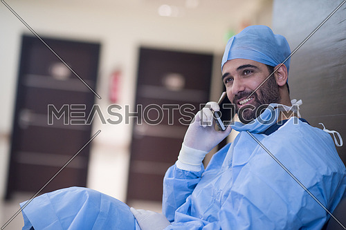 young middle eastern doctor talking on the phone in a large modern clinic