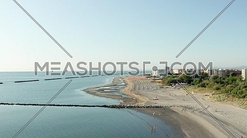 Aerial shot of sandy beach with umbrellas, typical adriatic shore.Summer vacation concept.Lido Adriano town,Adriatic coast, Emilia Romagna,Italy.