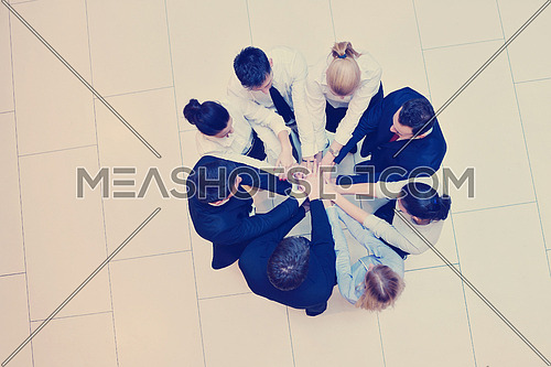 business people group joining hands and stay as team in circle  and representing concept of friendship and teamwork
