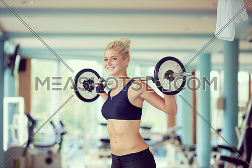 healthy and fit young woman in fitness gym lifting weights and working on her butt muscles