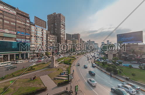 fixed shot for traffic in Gamet Al Dowal Street Showing Naguib Mahfouz Statue at Cairo at Day