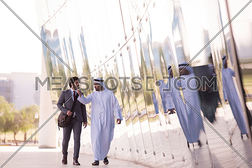 arabian  business people  walking in front of modern corporate building