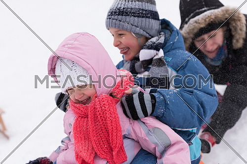 group of kids having fun and play together in fresh snow on winter vacation