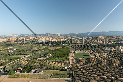 Panoramic view of the Calabrian hinterland, olive fields and wind turbines in the background, Calabria, Italy.