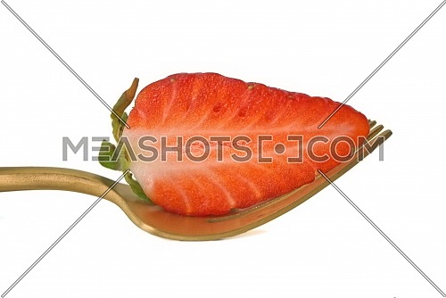 Half-cut strawberry on a golden fork isolated on a white background