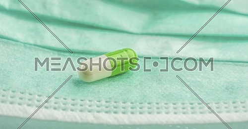 Capsule green and white on a masks of operating theater, conceptual image