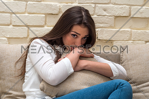 A young woman sits alone at home