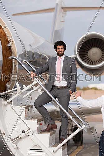Portrait of a young middle eastern successful businessman at the airport entering the private plane
