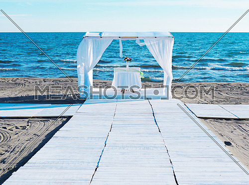 romantic white wedding table set up on tropical beach