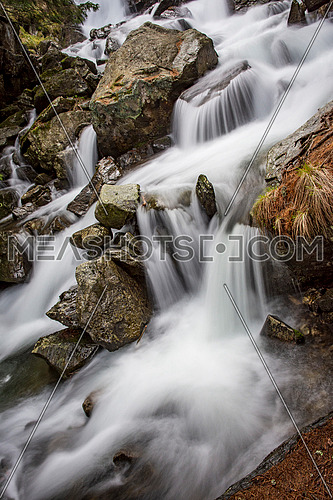 Beautiful river waterfall in autumn forest, a small waterfall part in Rhodope Mountains, Bulgaria