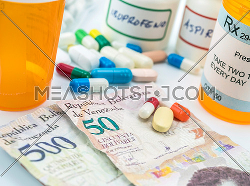 Medicines next to banknotes of Venezuela, shady deal of medication in full crisis of country of Latin America, conceptual image