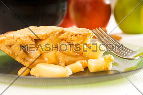 fresh homemade apple pie over green glass dish macro colseup eating  with fork