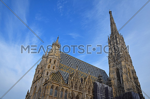 St Stephen Cathedral (Stephansdom) at Stephansplatz, the biggest cathedral and most important religious building in Vienna, Austria, over day blue sky, low angle side view