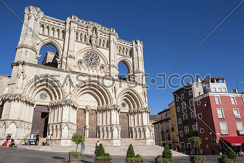 CUENCA, SPAIN - APRIL 2, 2016: Tourists walk near the facade of the Cuenca's Cathedral, The cathedral is dedicated to St Julian, gothic english-norman style, XII century, called the Basilica of Our Lady of Grace