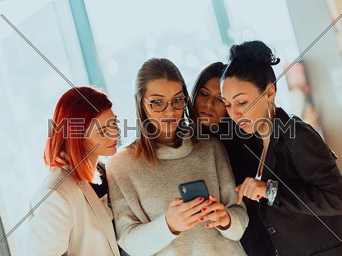 the womans use a smartphone on a break from work in their office