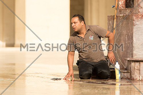 A janitor is cleaning the marble floor of Al-Hakim mosque in Al-Moez street, old Cairo