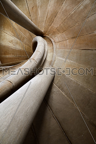 Spiral stone stair in old medieval tower, diminishing perspective, low angle view
