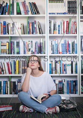 smart looking famale student girl  in collage school library reading book