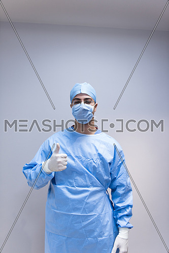 Portrait of a young middle eastern doctor with gloves on his hands in the modern clinic