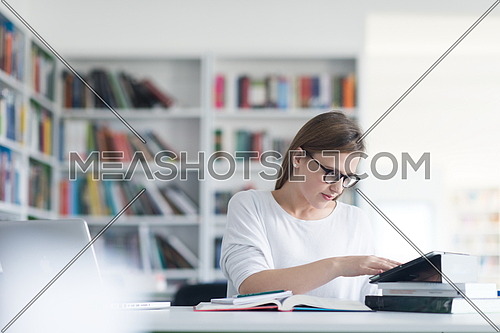female student study in school library, using laptop and searching for informations on internet