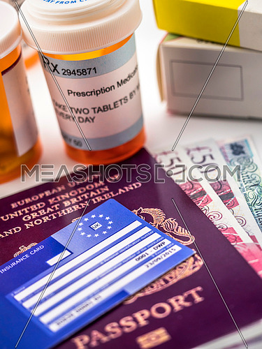British passport and European health insurance card along with several capsules, concept of medical increase in the crisis of the brexit, conceptual image, horizontal composition